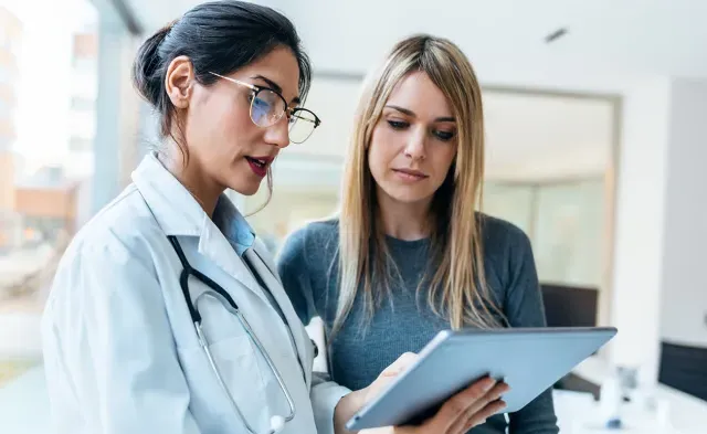 Women's health nurse practitioner reviewing test results with female patient