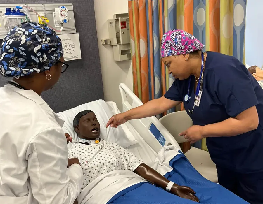 Undergraduate nursing student practicing on dummy during on-campus simulation experience