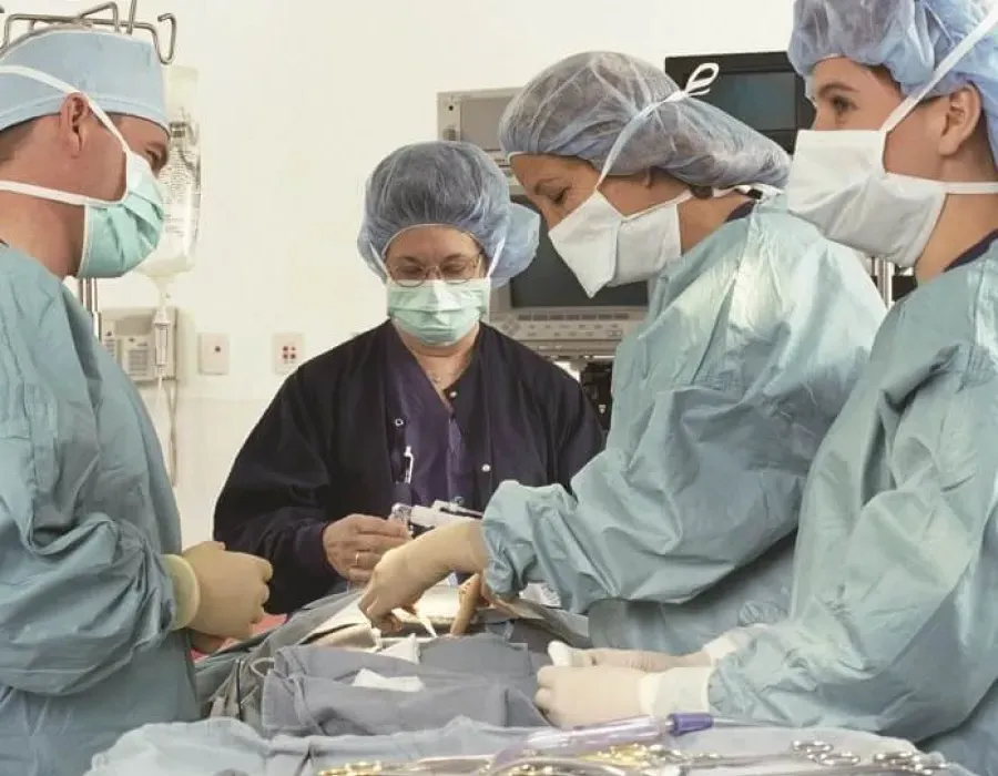 Nurse anesthetist assisting surgical team in advance of procedure